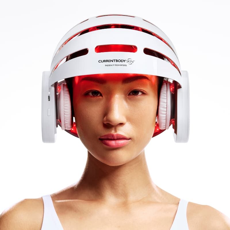 A woman wearing the CurrentBody LED hair growth helmet, photographed from the front.